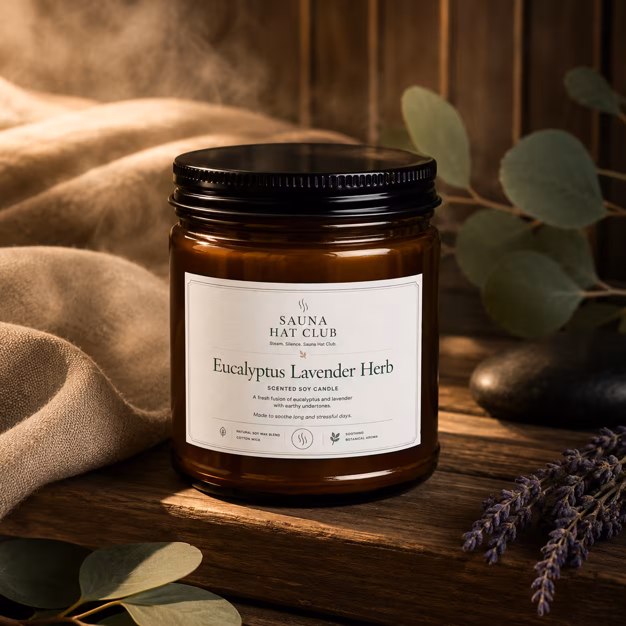 Eucalyptus Lavender Herb soy candle in amber jar styled with eucalyptus, lavender, stones, and sauna steam